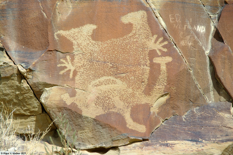 Petroglyph with mis-placed hands and feet next to grafitti.  Legend Rock, Wyoming.