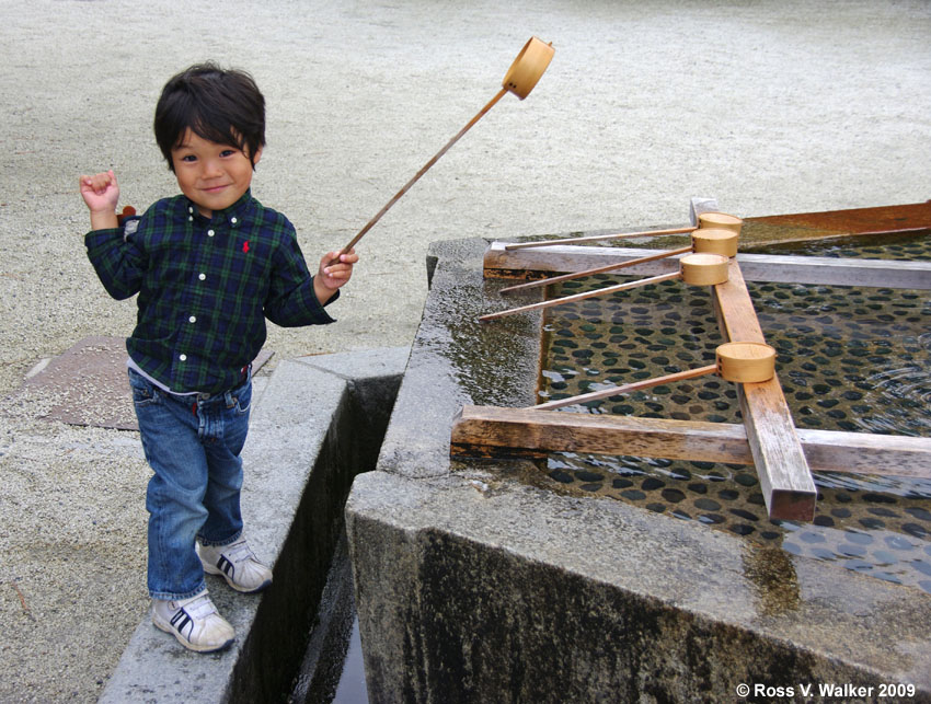 Boy at purification trough, Heian Shrine, Kyoto, Japan
