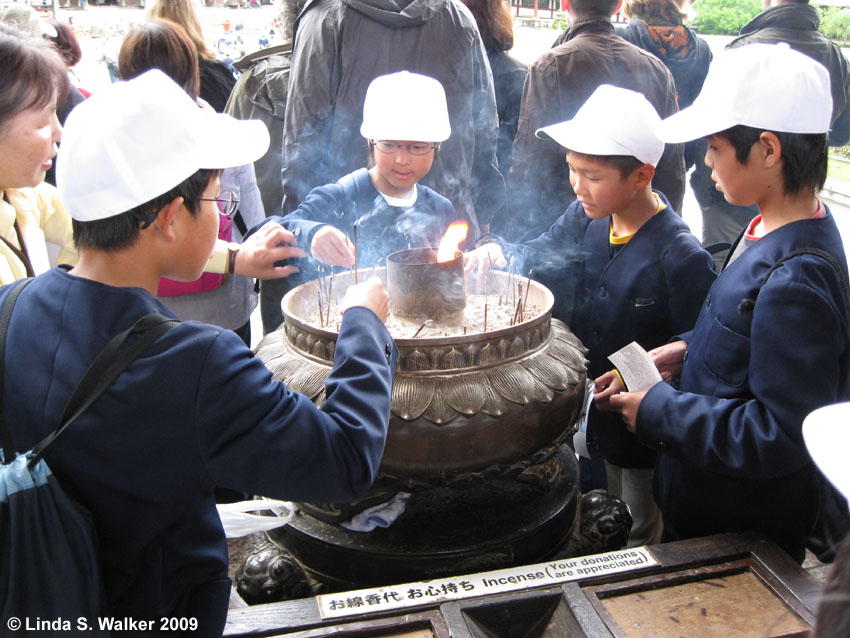 Kids lighting incense before visiting Todaiji Temple, Nara, Japan