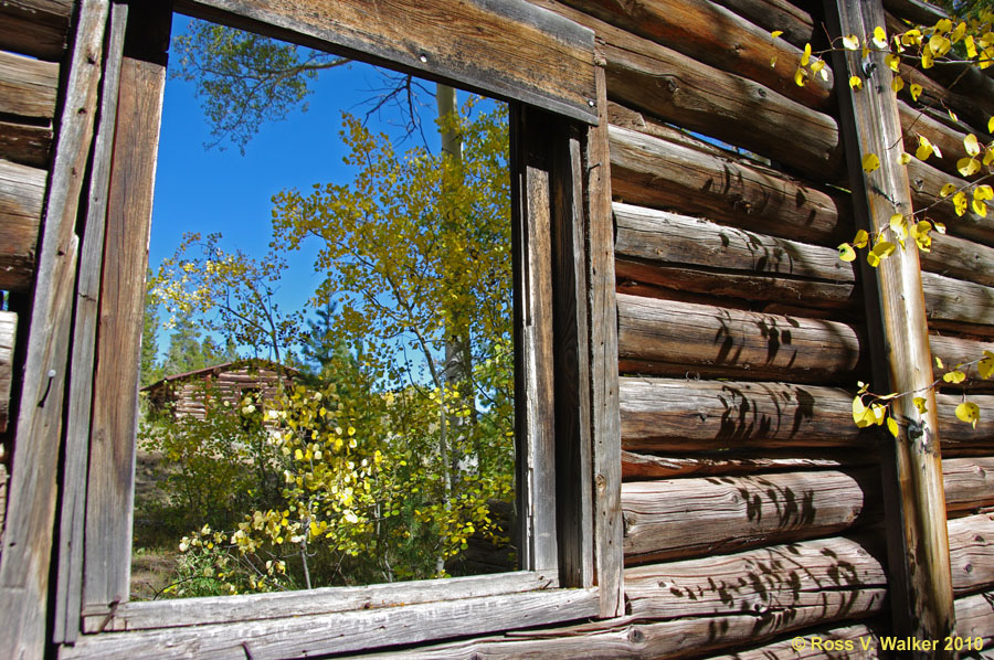Log cabin through a window, Miner's Delight, Wyoming