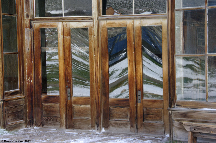 Snow reflections in the doors of the Wheaton and Hollis Hotel, Bodie, California