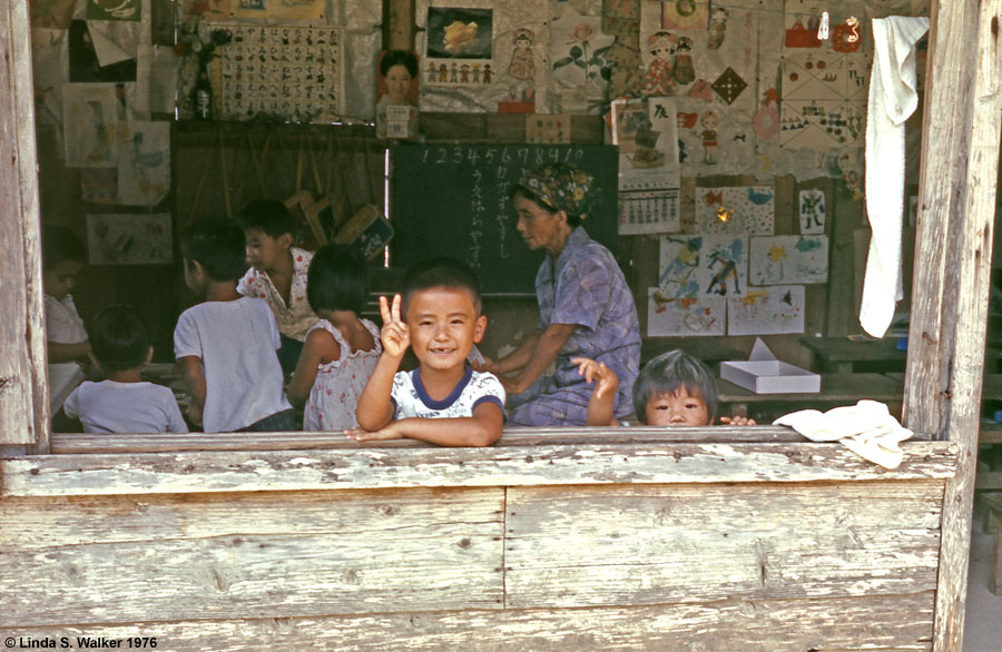 Child in kindergarten class window, Okinawa, Japan