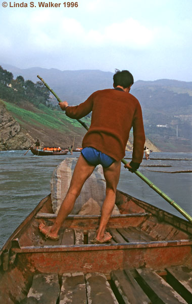 Crewmen pull a boat through the shallow Shengdong River, China