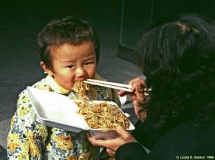 Child eating lunch, China