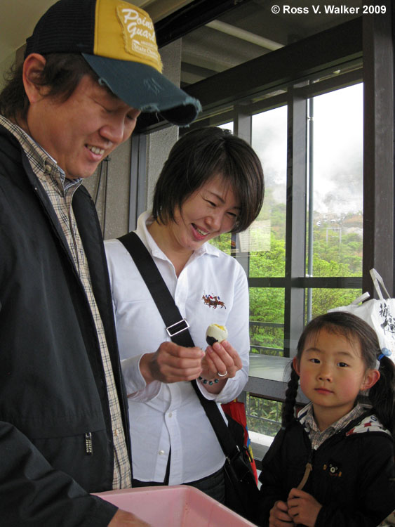 A family peels a black egg boiled in hot springs at Mt. Komagatake, Japan