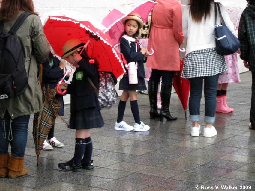 Kids wait for a bus in the rain, Odawara, Japan