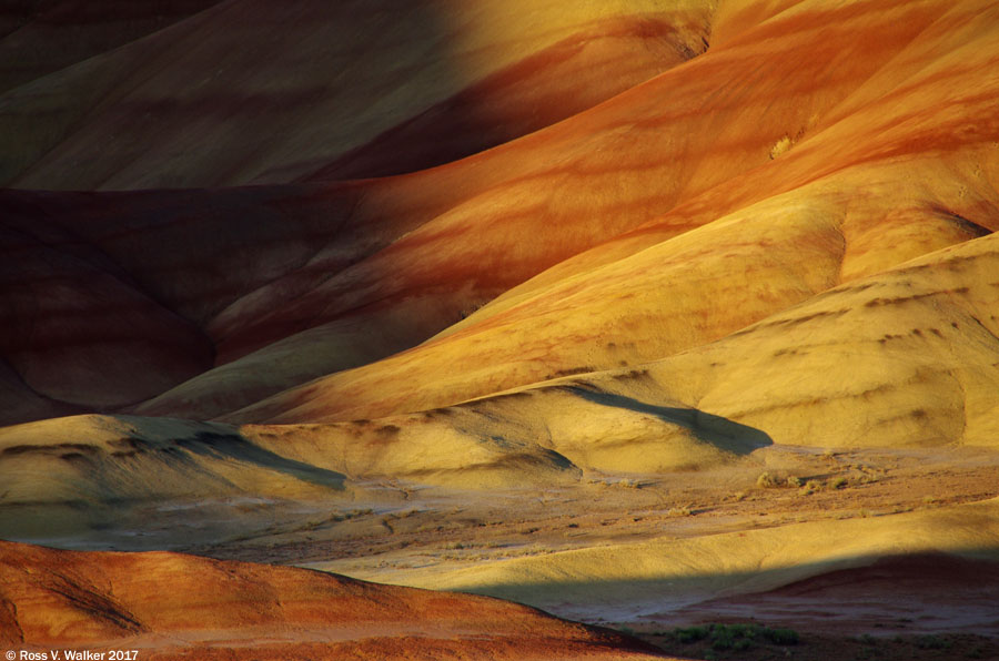 Shadows creep across the hills as evening advances at the Painted Hills, Oregon