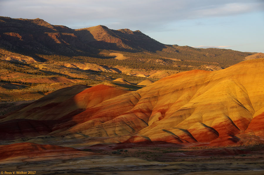 Shadows creep across the hills as evening advances at the Painted Hills, Oregon