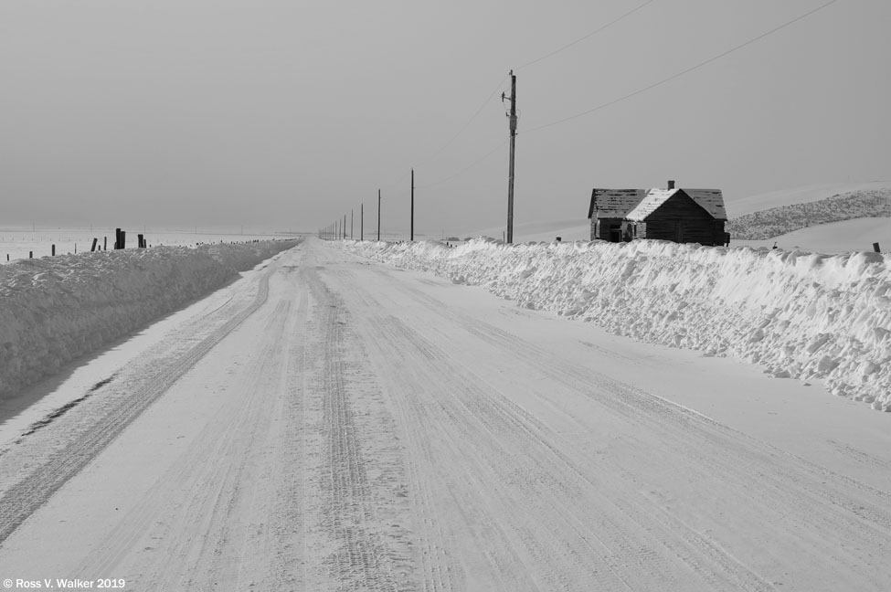 A country road disappears into distant winter mist, Bear Lake County, Idaho