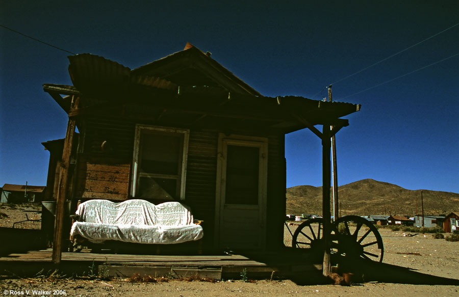 An old sofa has a ghostly glow on a darkened porch, Gold Point, Nevada