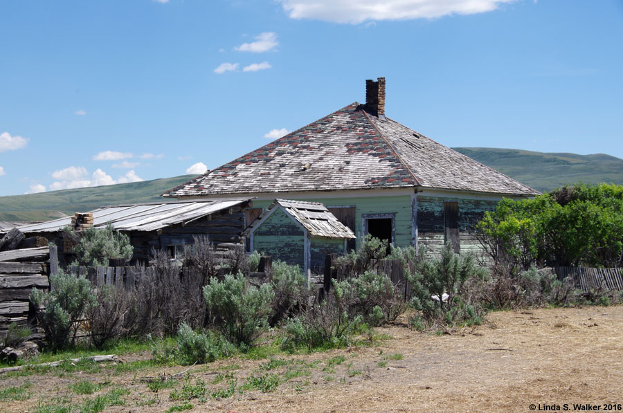 Abandoned house and barren hills at Sage, Wyoming
